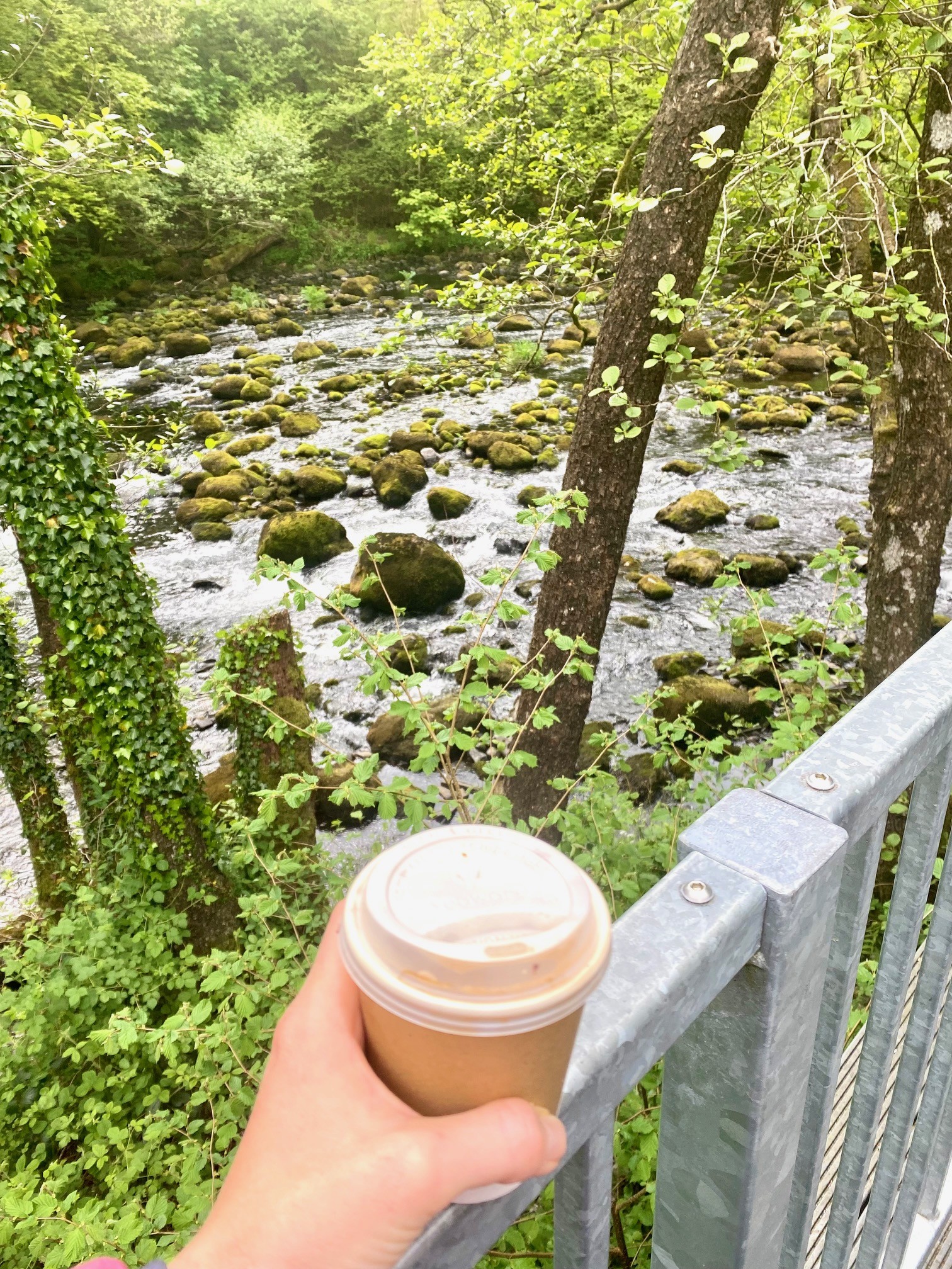 Holding a coffee cup in front of Brathay River